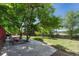 Large, grassy backyard area with patio seating and mature shade trees, perfect for outdoor activities and relaxation at 1572 W Long Ave, Littleton, CO 80120