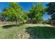 Green backyard featuring mature trees and a view of the deck at 1572 W Long Ave, Littleton, CO 80120