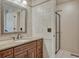 Bright bathroom features granite countertop vanity with a shower with glass doors in the background at 1572 W Long Ave, Littleton, CO 80120
