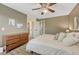 Bright bedroom with wood-look floors, ceiling fan, and view into another bedroom and bathroom at 1572 W Long Ave, Littleton, CO 80120