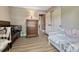 Cozy bedroom boasts wood-look floors, a dresser, closet and two cribs; one white and one espresso at 1572 W Long Ave, Littleton, CO 80120