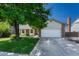 Charming home with a two-car garage, brick accents, and lush green lawn at 1572 W Long Ave, Littleton, CO 80120