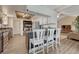 Bright, open kitchen with white cabinetry, bar seating, and stainless steel appliances at 1572 W Long Ave, Littleton, CO 80120