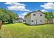 Large backyard with green lawn, two-story home, additional structure, and clear blue skies at 18355 W 59Th Dr, Golden, CO 80403