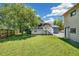 Lush backyard featuring a well-maintained lawn, mature tree, deck, and a two-story house at 18355 W 59Th Dr, Golden, CO 80403
