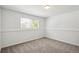 Bright, neutral bedroom with large window, light walls, and soft carpet flooring at 18355 W 59Th Dr, Golden, CO 80403