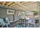 Relaxing covered deck with stylish furniture and a neighborhood view with blue accents at 18355 W 59Th Dr, Golden, CO 80403