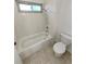 Clean and bright bathroom featuring a shower-tub combo, white tile, and modern fixtures at 3552 S Kittredge St # C, Aurora, CO 80013