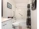 Tiled bathroom with a shower-tub combination with a shower curtain, grab bars, sink, and vanity at 7750 W 87Th Dr # C, Arvada, CO 80005
