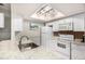 Bright kitchen features a skylight, white cabinets, appliances, and a granite countertop at 7750 W 87Th Dr # C, Arvada, CO 80005