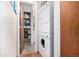 A laundry space with a stacked washer and dryer, shelving, and storage space at 7750 W 87Th Dr # C, Arvada, CO 80005