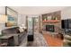 Living room featuring a stone fireplace, balcony, hardwood floors and neutral color palette at 7750 W 87Th Dr # C, Arvada, CO 80005