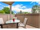 Outdoor patio featuring a round table with chairs and an exterior view of the surrounding trees and sky at 7750 W 87Th Dr # C, Arvada, CO 80005