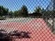 View of the community tennis court surrounded by mature trees, offering a recreational amenity for residents at 7750 W 87Th Dr # C, Arvada, CO 80005