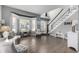 Bright living room featuring a staircase, hardwood floors, neutral walls, and a large bay window at 9683 Las Colinas Dr, Lone Tree, CO 80124