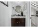 Elegant powder room featuring a marble countertop and a round mirror at 9683 Las Colinas Dr, Lone Tree, CO 80124