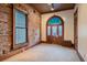 Cozy living room featuring exposed brick, arched doorway, vintage radiator, and neutral carpet at 1650 N Pennsylvania St, Denver, CO 80203