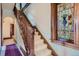 Staircase with carpeted steps, detailed wood banister, and colorful stained glass window at 1650 N Pennsylvania St, Denver, CO 80203