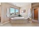 Bright bathroom featuring a luxurious soaking tub with scenic views from the window at 2116 Ridgetrail Dr, Castle Rock, CO 80104