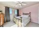 Bedroom with brass bed, pink accent wall, and two windows with scenic views at 2116 Ridgetrail Dr, Castle Rock, CO 80104