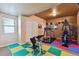 Basement gym featuring fitness equipment, colorful flooring, and a window for natural light at 2116 Ridgetrail Dr, Castle Rock, CO 80104