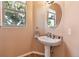 Charming powder room featuring a pedestal sink and decorative mirror, with a window at 2116 Ridgetrail Dr, Castle Rock, CO 80104