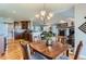 Elegant dining room with wood table and view of the open-concept kitchen and living spaces at 8233 E 149Th Dr, Thornton, CO 80602