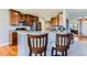 Open kitchen with granite countertops, stainless steel appliances, and bar seating overlooking the living area at 8233 E 149Th Dr, Thornton, CO 80602