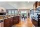 Bright kitchen features wood floors, granite countertops and stainless steel appliances, open to a dining area at 8233 E 149Th Dr, Thornton, CO 80602