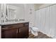 Bathroom features vanity, mirror, toilet and shower with curtain at 350 Mesa Ave, Lochbuie, CO 80603