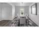 Dining room features a wooden table with seating for six, modern lighting, and wood floors at 350 Mesa Ave, Lochbuie, CO 80603