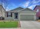 Charming single-story home with green siding, well-manicured lawn, and an attached two-car garage at 350 Mesa Ave, Lochbuie, CO 80603