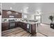 Open kitchen with dark cabinetry, granite countertops, stainless steel appliances with open access to the living room at 350 Mesa Ave, Lochbuie, CO 80603