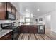 Spacious kitchen with dark wood cabinets, granite countertops, stainless steel appliances and opens to the living room at 350 Mesa Ave, Lochbuie, CO 80603