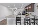 Open concept kitchen with bar stool seating, granite countertops, and stainless appliances connects to the dining room at 350 Mesa Ave, Lochbuie, CO 80603