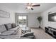 Bright living room with sliding glass doors to outdoor patio with stylish grey sectional couch at 350 Mesa Ave, Lochbuie, CO 80603
