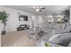 Cozy living room featuring a gray sectional sofa, ceiling fan, TV and opens to the kitchen at 350 Mesa Ave, Lochbuie, CO 80603