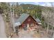 Aerial view of home with a covered deck, patio, and treetop views, blending with nature at 356 Castlewood Dr, Evergreen, CO 80439