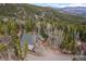A-frame style house nestled in wooded area with mountain views on a sunny day at 356 Castlewood Dr, Evergreen, CO 80439