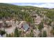 A-frame style house nestled in wooded area with a long dirt driveway and neighboring houses at 356 Castlewood Dr, Evergreen, CO 80439