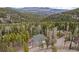 A-frame style house nestled in wooded area with mountain views on a sunny day at 356 Castlewood Dr, Evergreen, CO 80439