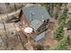 A-frame style house has an outdoor patio set, grill, and large deck with seating surrounded by forest at 356 Castlewood Dr, Evergreen, CO 80439