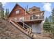 The backyard of the home has a basement access and is situated on a hill among the treeline at 356 Castlewood Dr, Evergreen, CO 80439