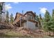 The backyard of the home has a basement access and is situated on a hill among the treeline at 356 Castlewood Dr, Evergreen, CO 80439