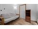 Bedroom featuring wood floors, a futon with neutral colored bedding, and a wooden door at 356 Castlewood Dr, Evergreen, CO 80439