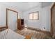 Bedroom featuring wood floors, a small window with a view, and a wooden door at 356 Castlewood Dr, Evergreen, CO 80439
