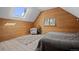 Attic bedroom with wood-paneled walls, skylight, and stylish chair and rug at 356 Castlewood Dr, Evergreen, CO 80439