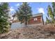 Charming home featuring wood siding and a sloped lot, blending with the natural surroundings at 356 Castlewood Dr, Evergreen, CO 80439