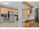 Modern kitchen with stainless steel appliances and wood cabinets, seamlessly connected to the living area, offering bar stool seating at 356 Castlewood Dr, Evergreen, CO 80439