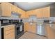 Well-lit kitchen with light wood cabinetry, stainless steel appliances, subway tile backsplash and granite countertops at 356 Castlewood Dr, Evergreen, CO 80439